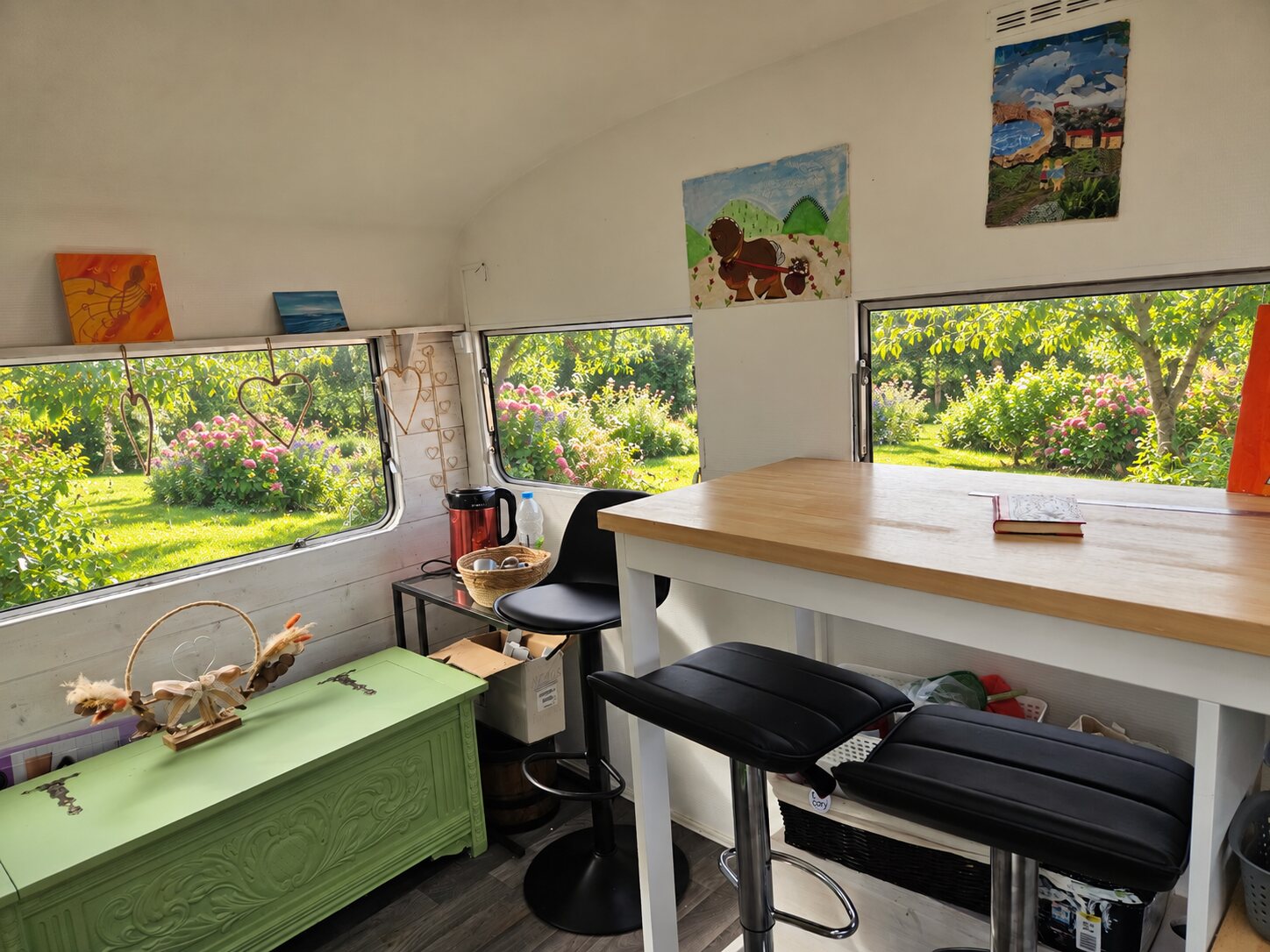 Table de travail dans la caravane thérapeutique Au fil d'Ergo, fenêtres ouvertes sur le jardin
